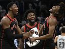 Raptors guard RJ Barrett, left, guard Jamal Shead, centre, and guard Ja'Kobe Walter celebrate a win against the Orlando Magic.