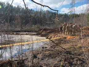 In this image provided by the US Army, US Army soldiers from the 1st Armored Brigade Combat Team, 3rd Infantry Division, along with Lithuanian Army and emergency services personnel, discuss their plan to recover four US soldiers in a US Army M88 Hercules submerged under several metres of water in a swamp near a training area near Pabadre, Lithuania, Thursday, March 27, 2025.