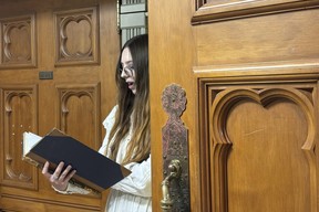 A tour guide at New Zealand's parliament gives a spooky tour of the historical Parliament library. (AP Photo/Charlotte Graham-McLay)