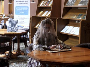 A tour guide at New Zealand's Parliament gives a spooky tour of the historical Parliament library, constructed in the late 19th century and rumored to be haunted, in Wellington, Thursday, March 20, 2025. (AP Photo/Charlotte Graham-McLay)