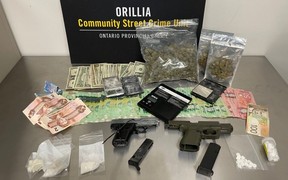 The Ontario Provincial Police seized cash, drugs and guns from a man in Scarborough alleged to have been dealing drugs in Simcoe County.