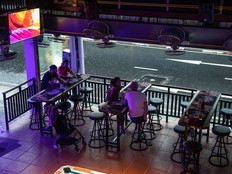 Customers have a drink at a near-empty bar during a rainstorm in Patong, Phuket, Thailand, on Saturday, Dec. 19, 2020.