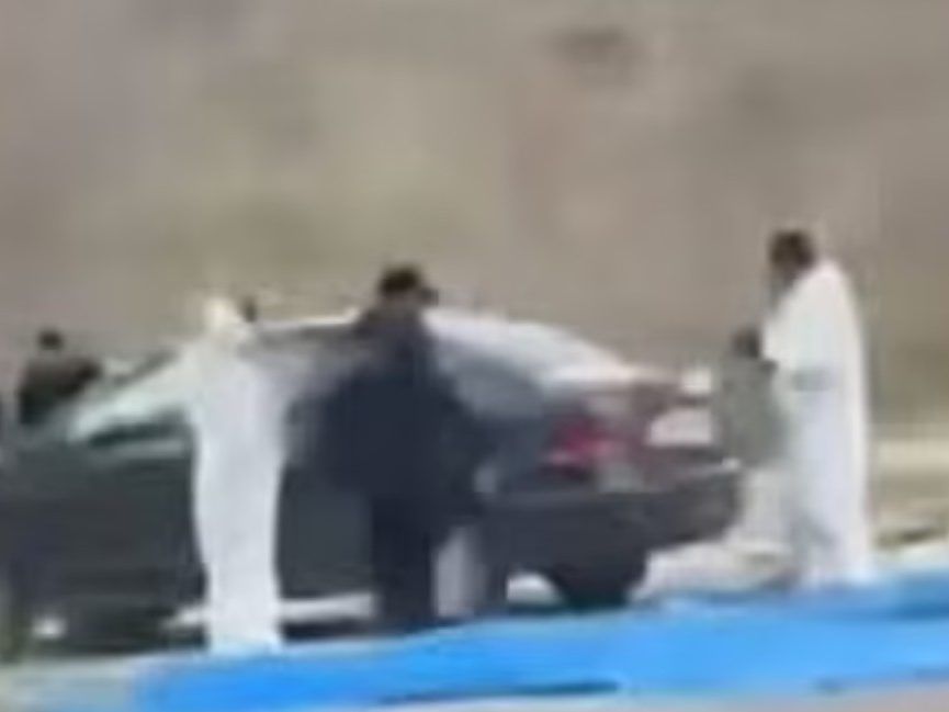 investigators at vehicle where remains of nine students were found.