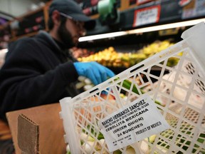 Isaac Arguelles stocks Mexican-grown green onions at a market as tariffs against Mexico go into effect Tuesday, March 4, 2025, in San Diego.