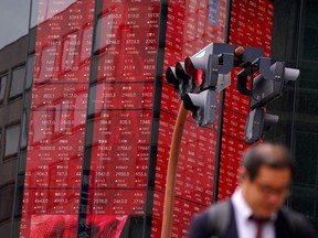 One person walked past an electronic board and showed the Nikkei 225 index.