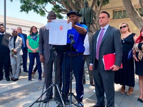 FILE - Jonathan Wright, 39, holds up the T-shirt he was given when he first went to MacLaren Children's Center in El Monte as an 8-year-old during a news conference in Los Angeles, June 9, 2022.