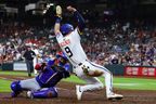 Zach Dezenzo of the Houston Astros avoids the tag of Jays catcher Alejandro Kirk to score in the seventh inning at Daikin Park on Monday. Alex Slitz/Getty Images