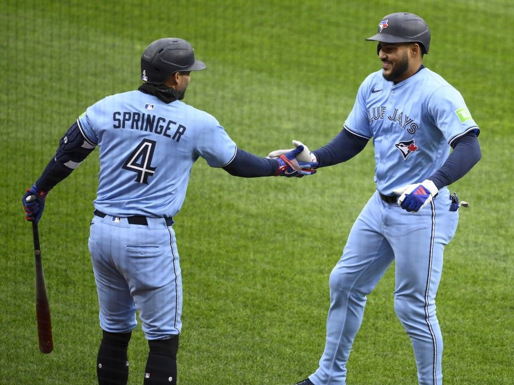 Blue Jays' Anthony Santander, right, celebrates after hitting his first home run with Toronto with George Springer, left, during the third inning of a game against the Orioles in Baltimore, Saturday, April 12, 2025.