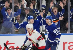 Toronto Maple Leafs Steven Lorentz (18) and Toronto Maple Leafs Oliver Ekman-Larsson (95) celebrate a goal as Ottawa Senators centre Dylan Cozens (24) skates past during first period period NHL playoff action in Toronto, on Sunday April 20, 2025. THE CANADIAN PRESS/Frank Gunn