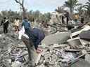 People travel through the ruins of three-story buildings after an Israeli strike near Al-Manara in Khan Yunis on April 4, 2025.