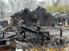 Firefighters look through the remains of a home that was destroyed in a fire that killed the owner and several rescue cats in Medford, N.Y., on Monday, March 31, 2025.
