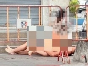 Blurred-out photo of couple having sex by entrance of famed Walking Street in Pattaya, Thailand.