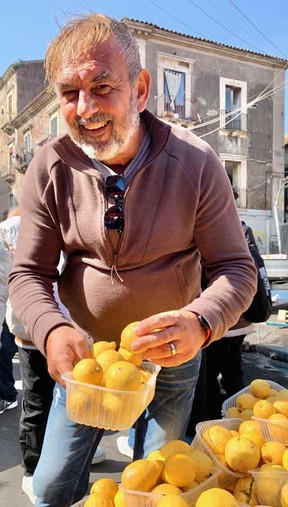 Italian-born chef Dario Tomaselli, an instructor at George Brown College in Toronto, checks out lemons at the outdoor market in Catania, Sicily, in March 2025.