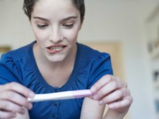 A woman mulls when to share her pregnancy news with her partner.