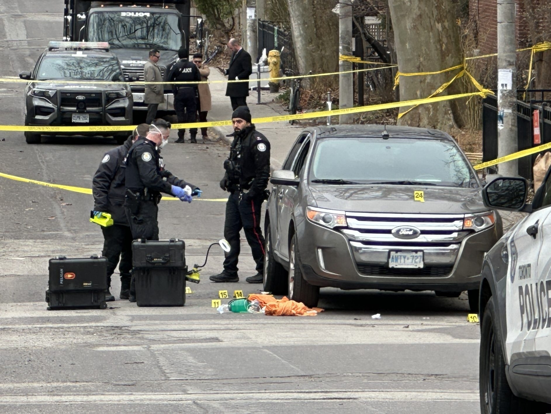  Investigators gather evidence the morning after two males were gunned down near Bain and Logan Aves., in Toronto’s Riverdale neighbourhood, on Wednesday, April 16, 2025.