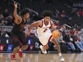 Rutgers guard Dylan Harper (right) drives against Southern California guard Wesley Yates III.