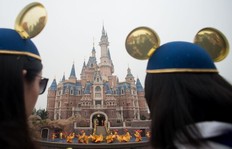 Women wearing Mickey Mouse ears watch the opening ceremony of the Shanghai Disney Resort in Shanghai on June 16, 2016.