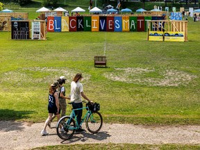 Visitors gather near a large "Black Lives Matter" and "I cant Breathe" murals at the Rise and Remember Festival in Minneapolis, Minnesota, on May 25, 2025, marking the fifth anniversary of George Flyod's death.