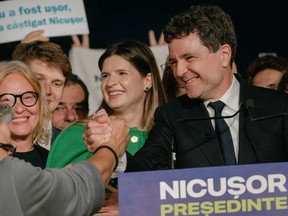 大統領候補のニクーザーダンは、2025年5月18日にルーマニアのブカレストで開催された大統領選挙当日の調査の最初の出口の後、支持者を歓迎します。