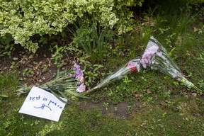 A message of “rest in peace” is seen among bouquets of flowers left outside the home. ERNEST DOROSZUK/TORONTO SUN