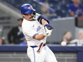 Davis Schneider of the Toronto Blue Jays hits a single.
