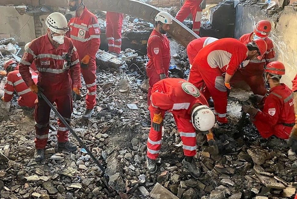  This handout picture released by the Iranian Red Crescent on June 17, 2025 shows members of their rescue teams searching the debris inside a buidling in Tehran, targeted by Israeli strikes.