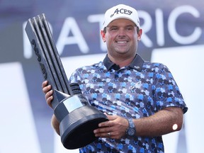 Patrick Reed of Aces GC holds the individual champion trophy.
