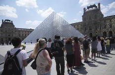 Tourists wait in line outside the Louvre museum which failed to open on time Monday, June 16, 2025 in Paris.