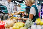 Supermarket cashier scanning groceries at the checkout.