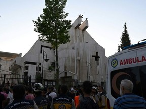People and rescuers gather at the site of a the suicide attack at Saint Elias church in Damascus on SundayLOUAI BESHARA/AFP