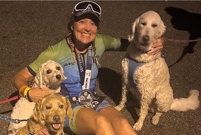 Walker poses with a trio of dogs after running an Ironman triathlon in Cambridge, Maryland, in September.