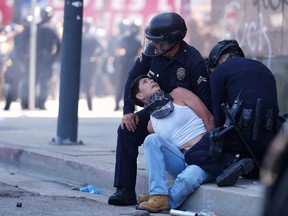 A protester is detained in downtown Los Angeles, Sunday, June 8, 2025, following last night's immigration raid protest.