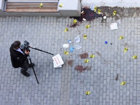 A bird’s-eye view of a Toronto Police officer taking pictures at a crime scene in Lawrence Heights on June 4, 2025, the day after one person was killed and five wounded in a mass shooting. (Jack Boland, Toronto Sun)