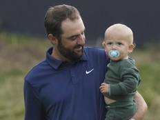 Scottie Scheffler walks with his son Bennett as he poses for photographers with the Claret Jug trophy after winning the British Open.