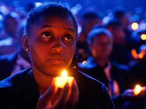 A young Rwandan takes part in a candle light vigil.
