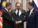 Cambodia's Prime Minister Hun Manet (L) and Thailand's acting Prime Minister Phumtham Wechayachai (R) shake hands as Malaysia's Prime Minister Anwar Ibrahim (C) puts his arms around them following a press conference after talks on a possible ceasefire between Thailand and Cambodia in Putrajaya on July 28, 2025. Thailand and Cambodia began discussing a ceasefire in their festering border dispute on July 28, as the deadly skirmish dragged into a fifth day. (Photo by MOHD RASFAN / POOL / AFP)