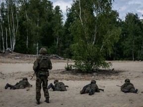 A military instructor keeps an eye on volunteers during a military training that is part of the “Vacation with the Army” project. (Wojtek RADWANSKI/AFP)