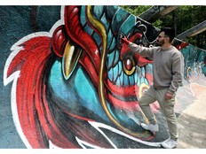 Street artist Kerim Musanovic puts the finishing touches to touches to a painting on the former Olympic bobsled track at Mount Trebevic, near Sarajevo.