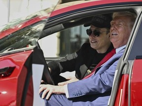 FILE - President Donald Trump and Tesla CEO Elon Musk speak to reporters as they sit in a red Model S Tesla vehicle on the South Lawn of the White House, March 11, 2025, in Washington. (Pool via AP, File)