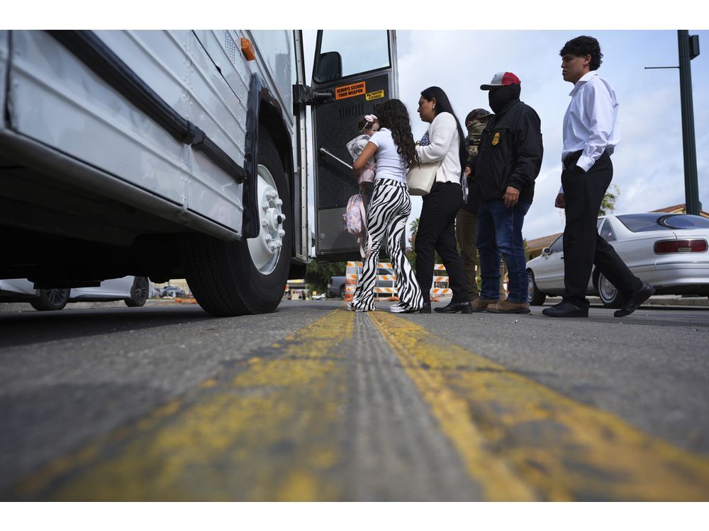 A family from Colombia is detained and escorted to a bus by federal agents following an appearance at immigration court Monday, July 14, 2025, in San Antonio.