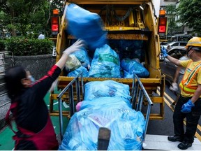 Taipei residents are also required to buy government-approved blue plastic bags for their general waste to encourage them to use less and recycle more. (I-Hwa Cheng/AFP)