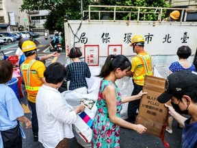 For the elderly, taking out the trash has become a social event and many arrive early to sit and talk around the collection pointsI-Hwa Cheng/AFP