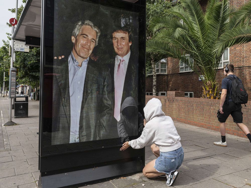 Activists put up a poster showing President Donald Trump and Jeffrey Epstein near the U.S. Embassy in London, Thursday, July 17, 2025. 