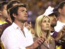 Former Arizona State player Pat Tillman's wife Marie Tillman, centre, and his brother Richard Tillman, left, applaud as they watch Pat's name and jersey number enshrined in the university's ring of honor during halftime ceremonies between Washington State and Arizona State, Nov. 13, 2004, in Tempe, Ariz.