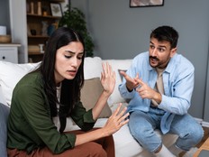 Young married couple husband and wife sitting at home having problems in their marriage and a cold relationship. A boyfriend and a girlfriend roommates have an argument about spending too much money