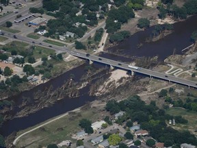 Cars pass a bridge over the Guadalupe River on Tuesday, July 8, 2025, after a flash flood swept through the area in Kerrville, Texas.