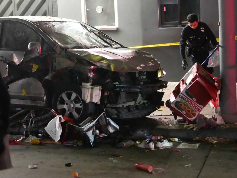 A vehicle sits on the sidewalk after ramming into a crowd of people waiting to enter a nightclub along a busy boulevard in Los Angeles early Saturday, July 19, 2025 injuring several people.  