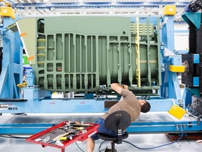 An employee works on the aft fuselage of a Boeing Co. F-15 Strike Eagle fighter aircraft at the Boeing Defense, Space & Security facility in St. Louis, Mo., on Monday, July 24, 2018.