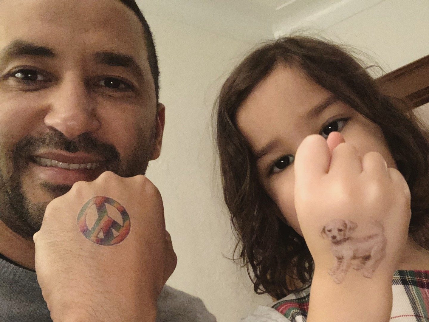  Luciano Frattolin and daughter Melina in 2023 showing off tattoos on hands.