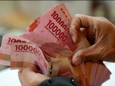 A man counts Indonesian rupiah banknotes at a currency exchange office in Jakarta, Indonesia, on Thursday, Oct. 5, 2023.
